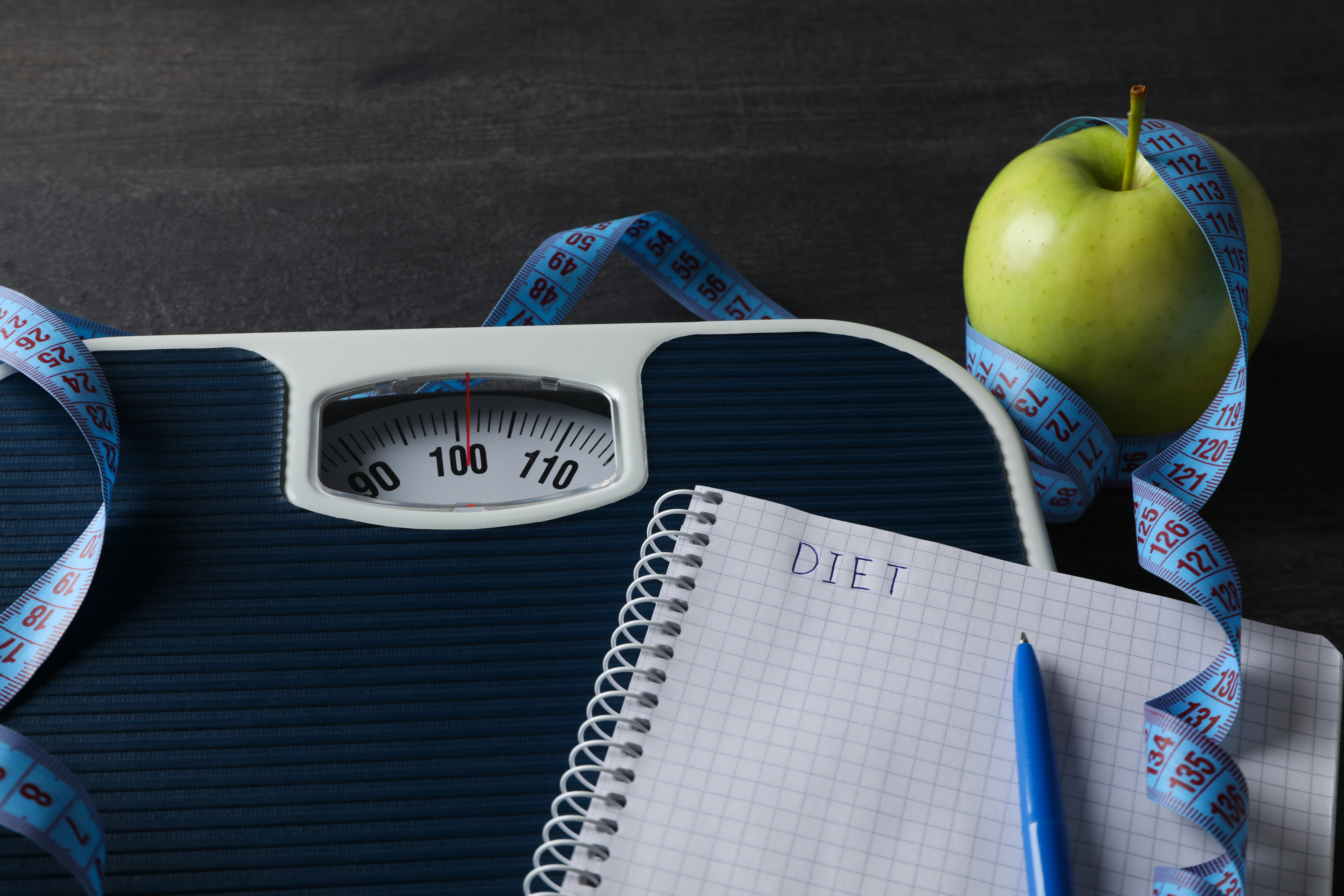 Concept of weight loss and healthy nutrition with apple and measuring tape